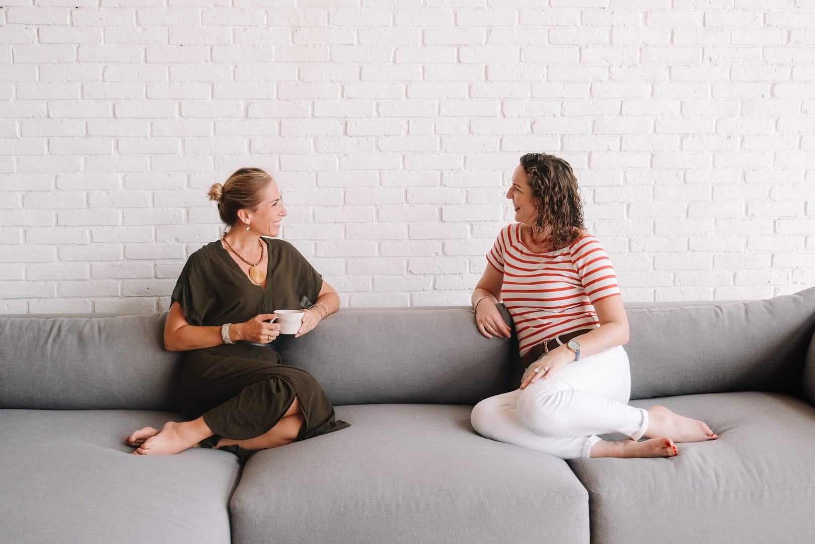 Two women chatting on a sofa