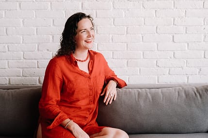Sarah Potter, Hypnocoack Lady in a red dress on a sofa